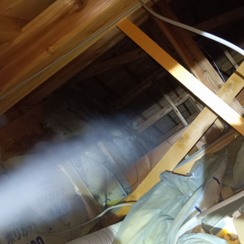 屋根裏に忌避剤を散布する様子