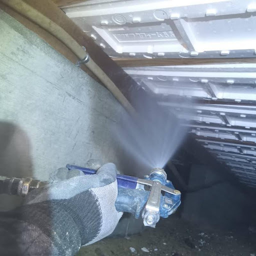 床下の木部にシロアリ駆除剤を吹き付けている様子