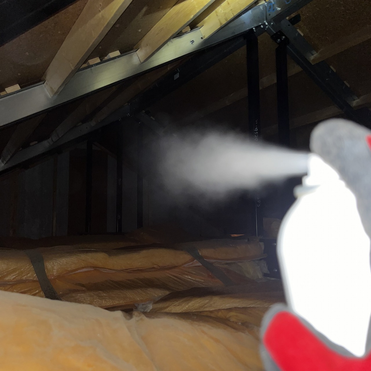 屋根裏に忌避剤を散布する様子