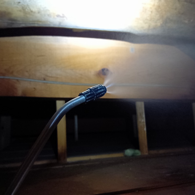 屋根裏に除菌・殺虫剤を散布する様子