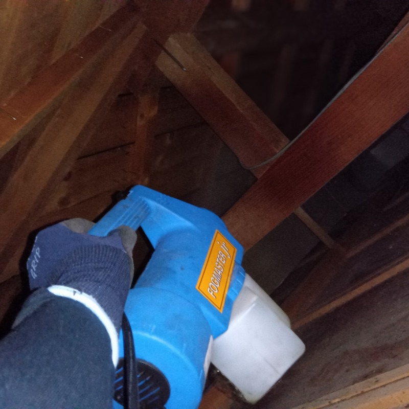 屋根裏に除菌・消臭剤を散布する様子