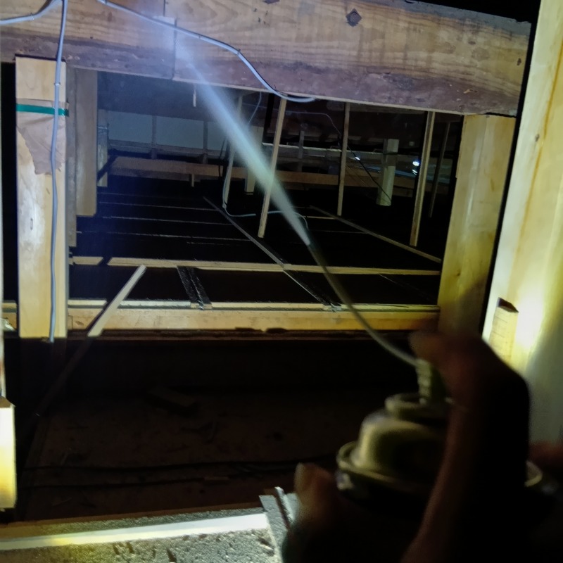 屋根裏に忌避剤を散布する様子