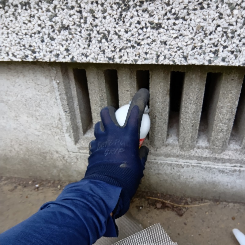 床下に忌避剤を散布する様子