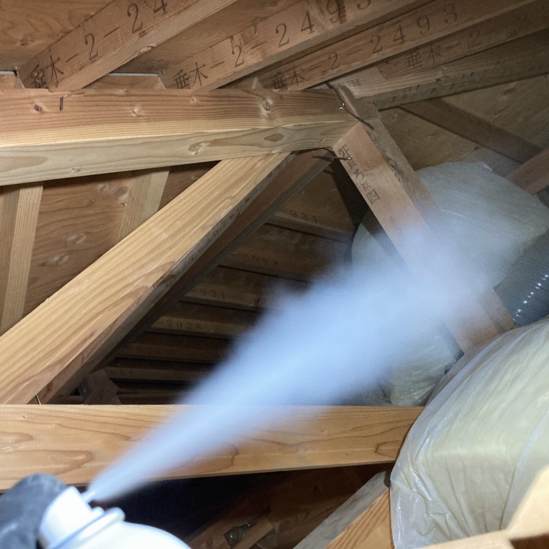 屋根裏に忌避剤を散布する様子