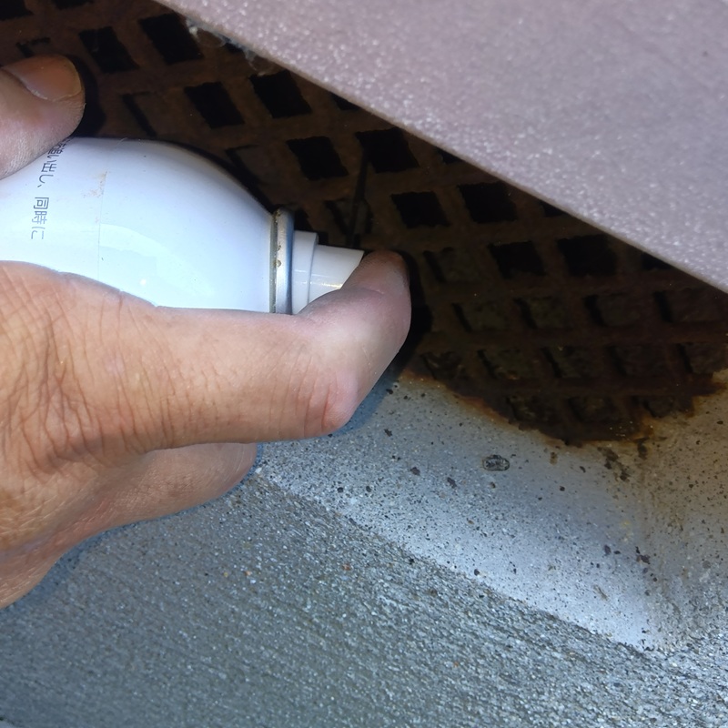 床下に忌避剤を散布する様子