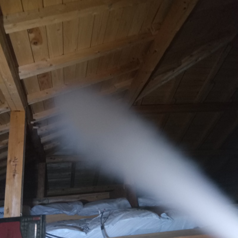 屋根裏に忌避剤を散布する様子