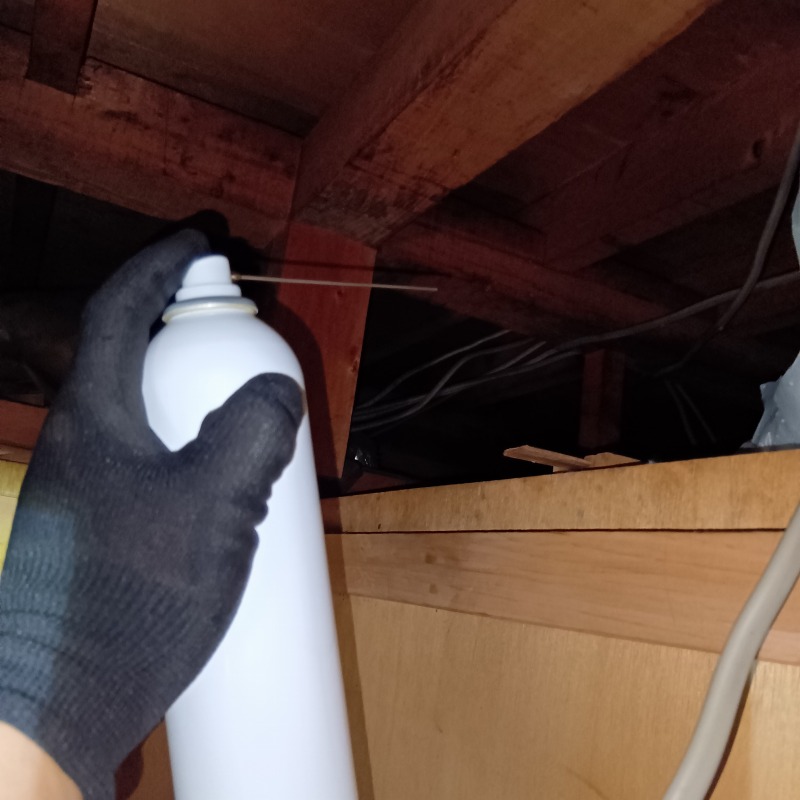 屋根裏に忌避剤を散布する様子