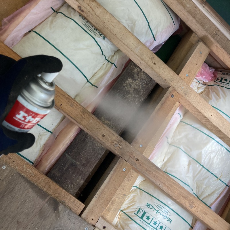 屋根裏に殺虫剤を散布する様子