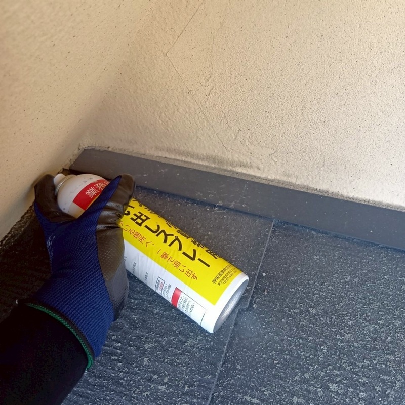 屋根のすき間から忌避剤を注入する様子