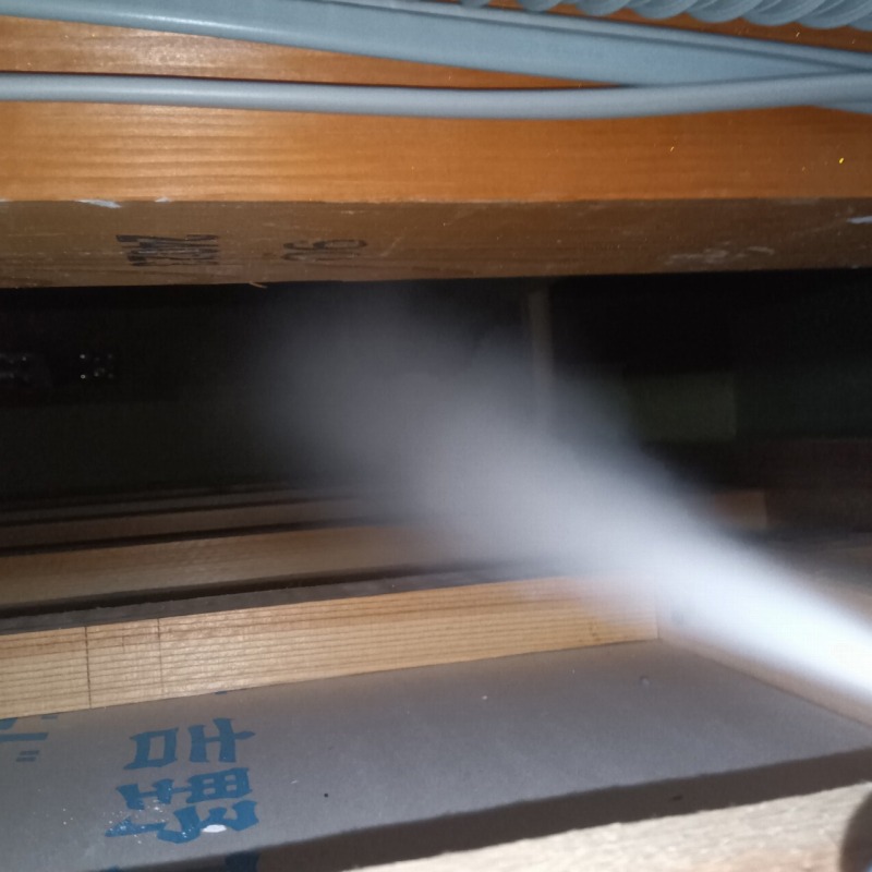 屋根裏に殺虫剤を散布する様子