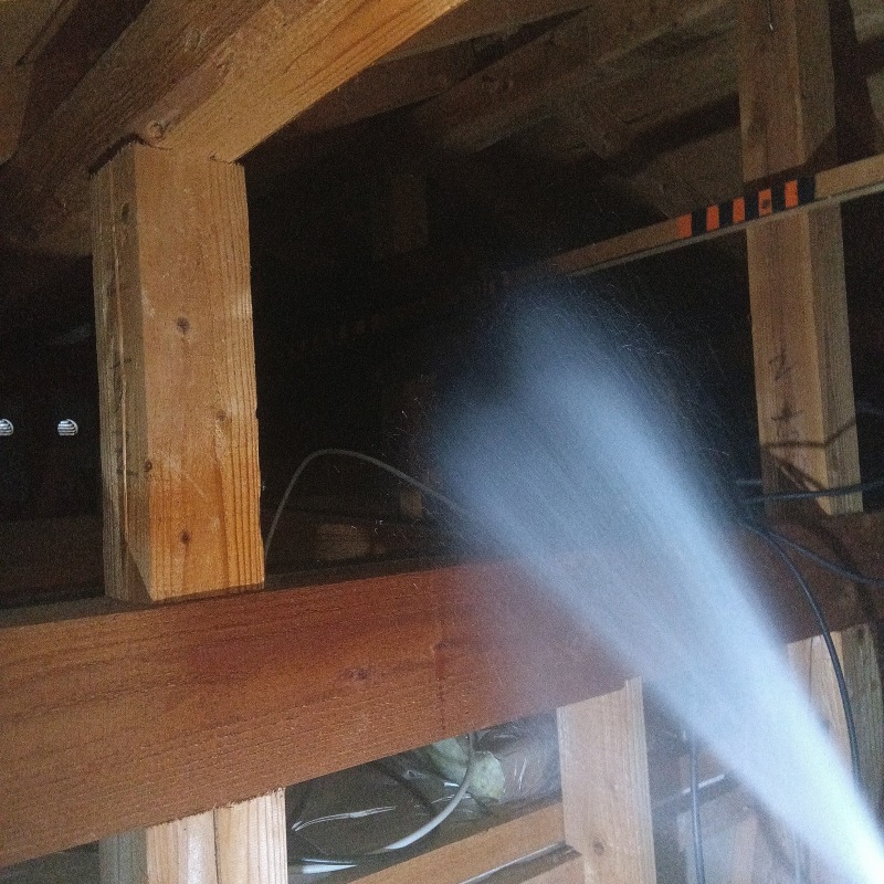 屋根裏の木材にシロアリ駆除剤を散布