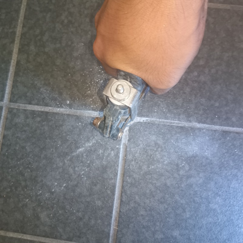 玄関の床に穴を開けてシロアリ駆除剤を注入