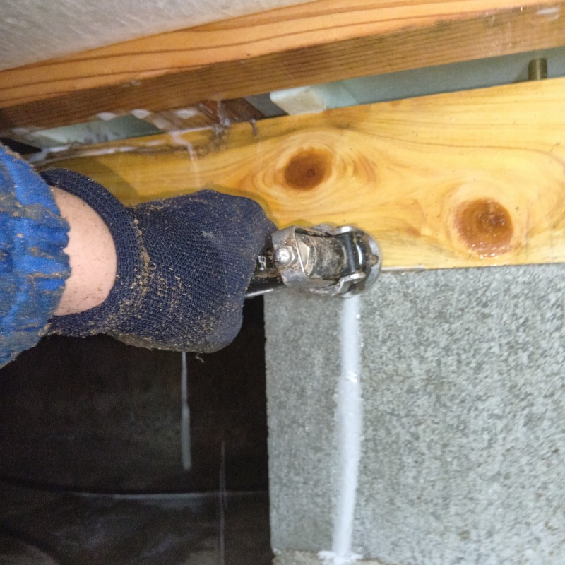 基礎と木材の接合部にシロアリ駆除剤を注入する様子