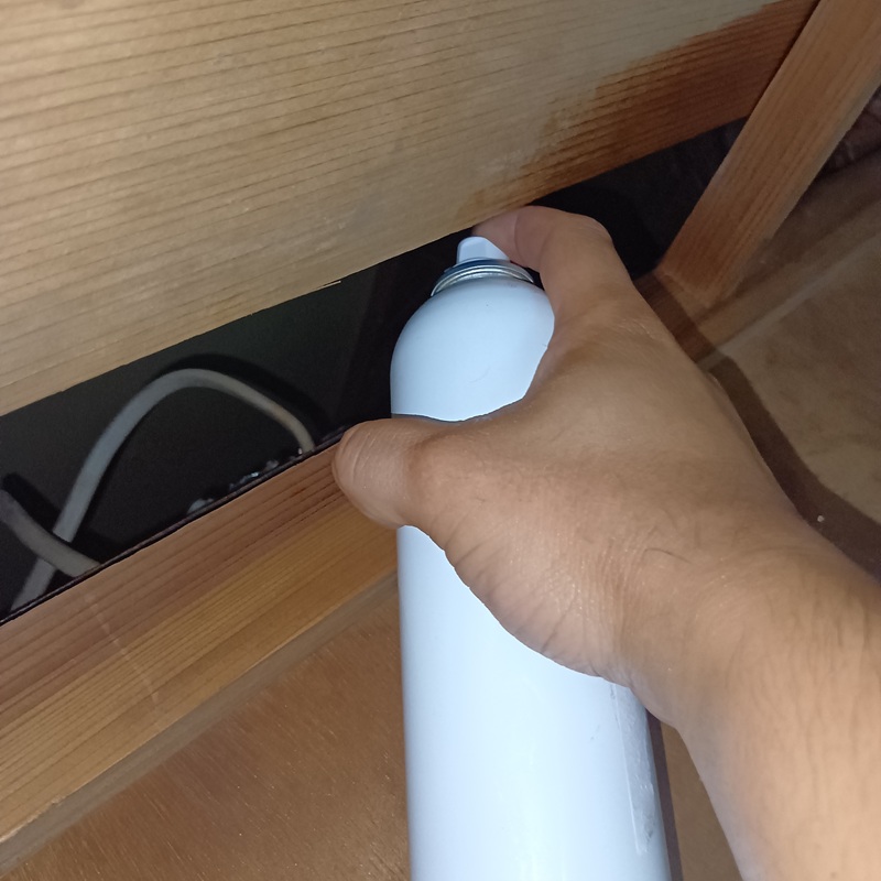 屋内のすき間に忌避剤を散布する様子