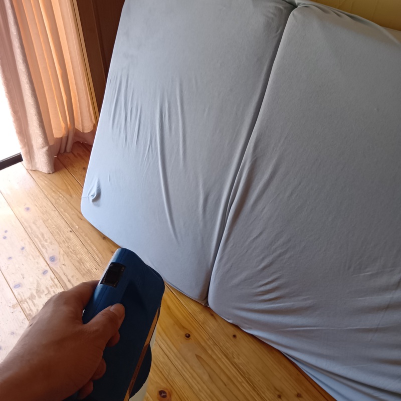 寝具に除菌・殺虫剤を散布する様子