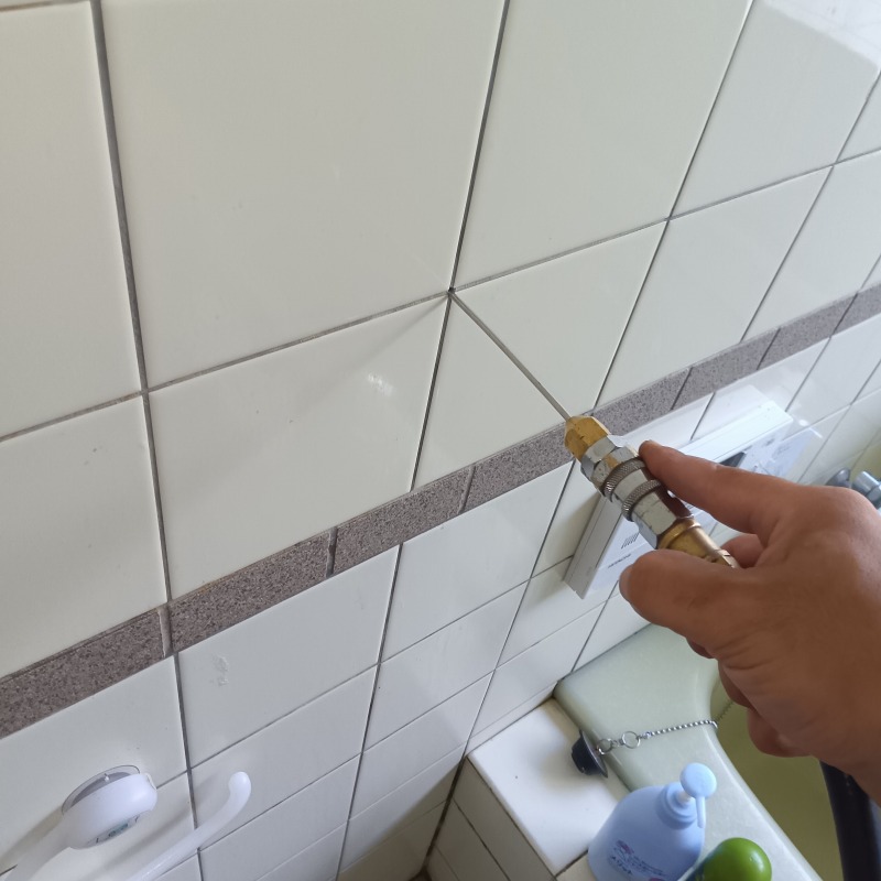浴室のタイル壁に穴を開けてシロアリ駆除剤を注入