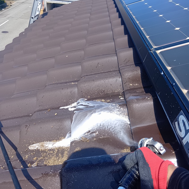 屋根の上のフンを高圧洗浄で清掃する様子