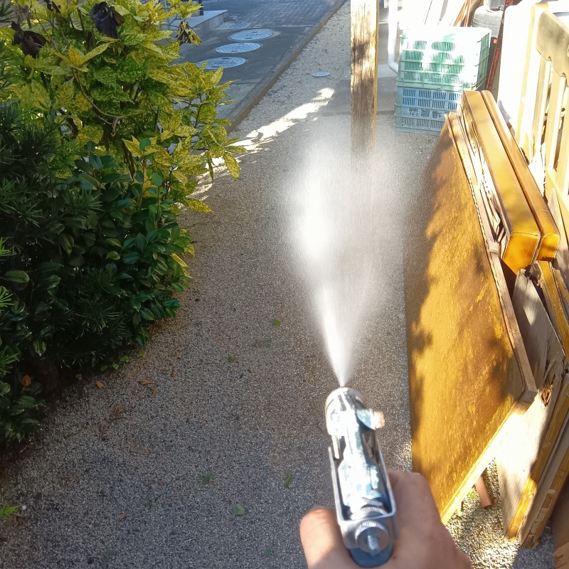 屋外の廃材にシロアリ駆除剤を散布