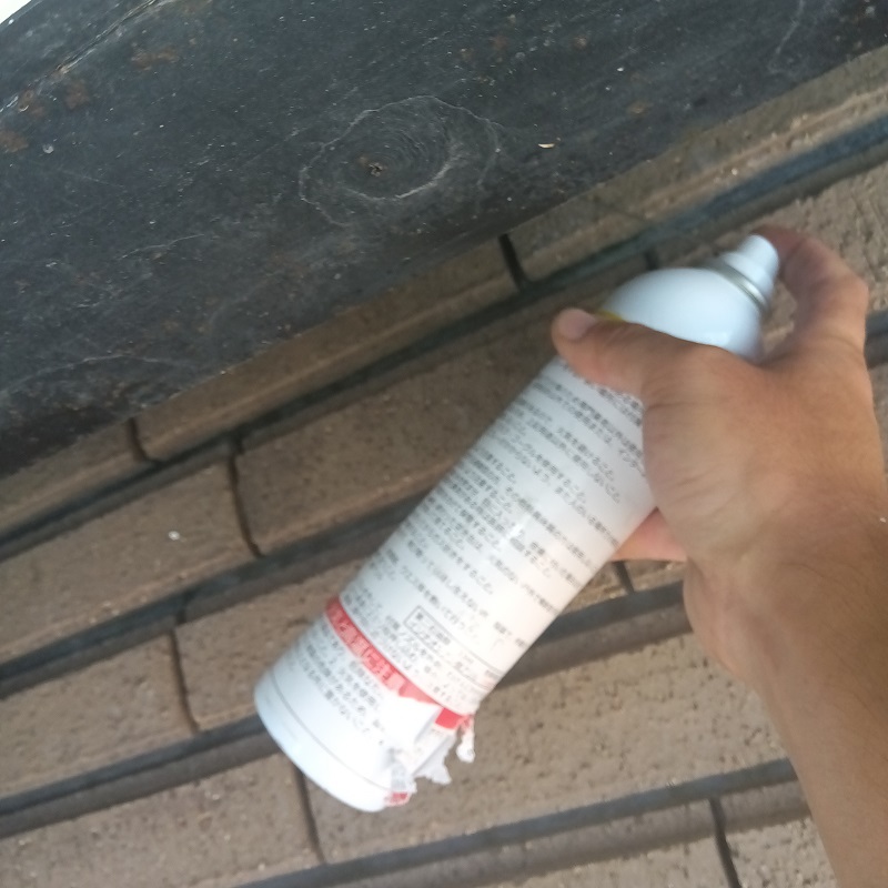 外壁に小さな穴を開けて忌避剤を注入する様子