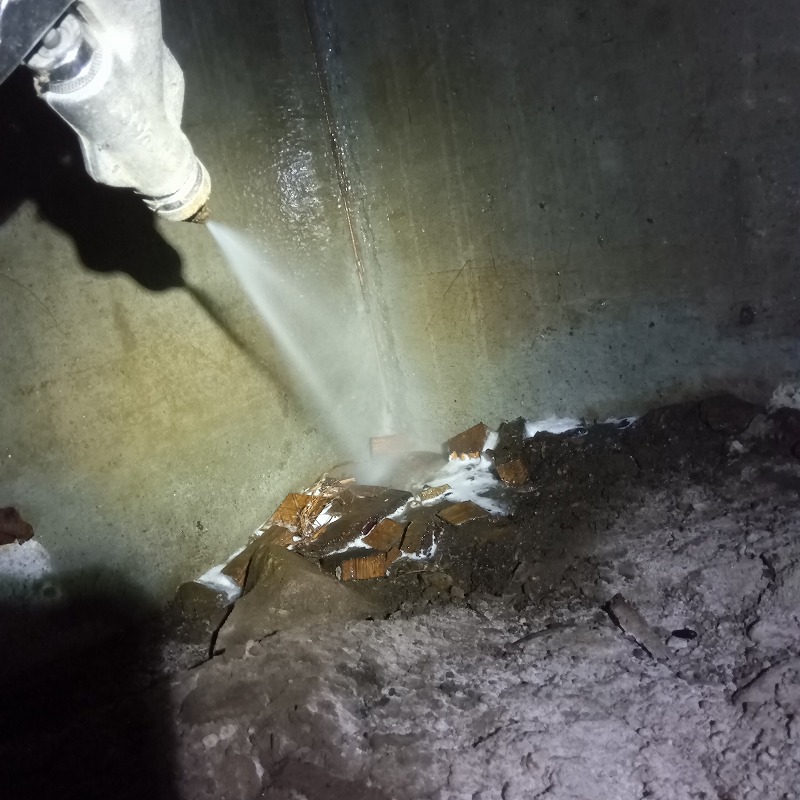 床下の地面にシロアリ駆除剤を散布する様子