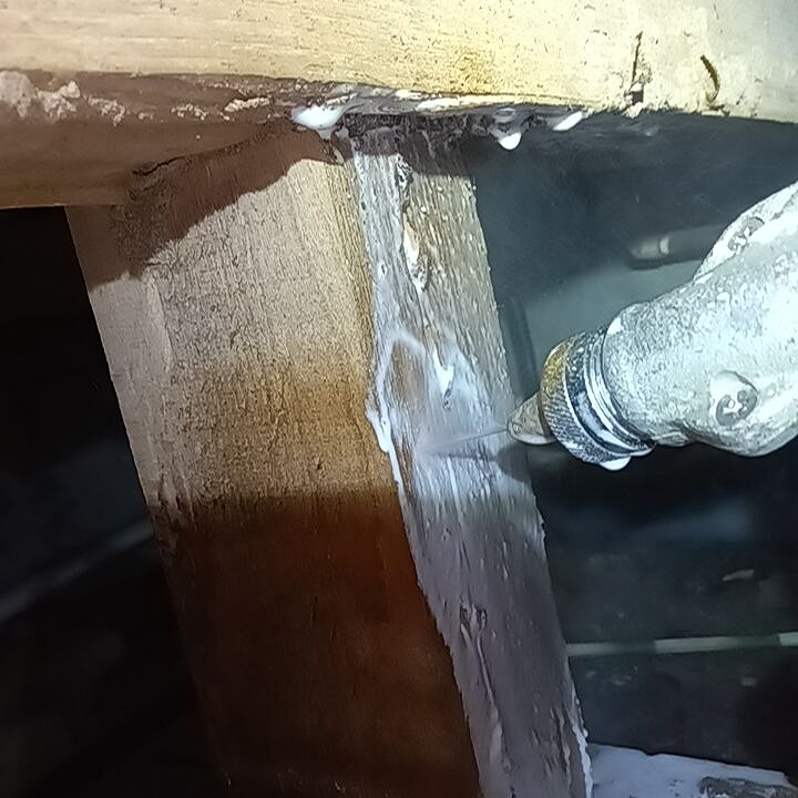 床下の木材に穴を開けてシロアリ駆除剤を注入