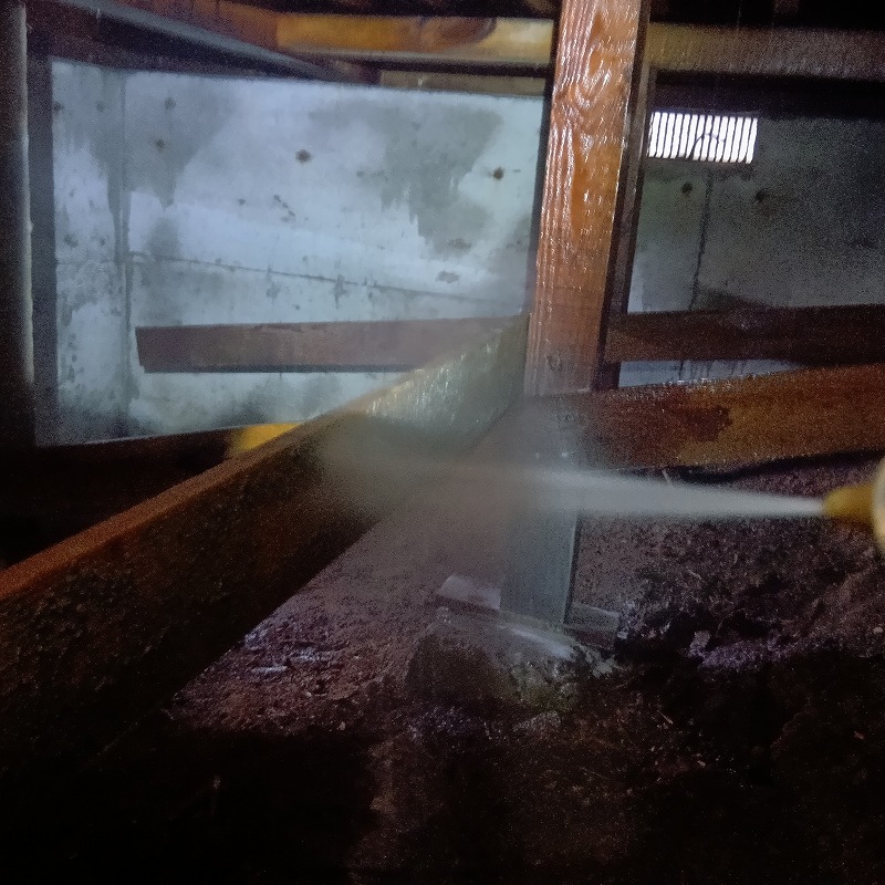 床下の木材にシロアリ駆除剤を散布する様子