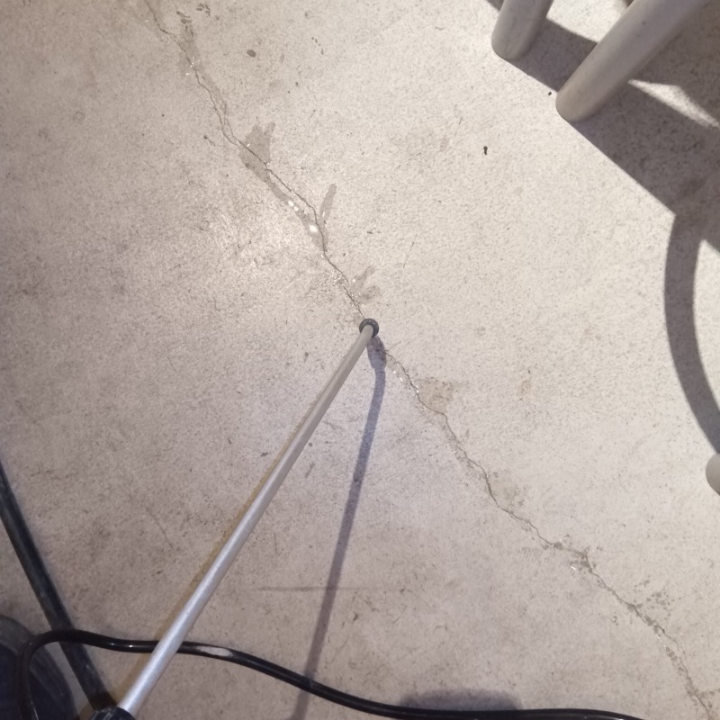 床に穴を開けてシロアリ駆除剤を注入する様子