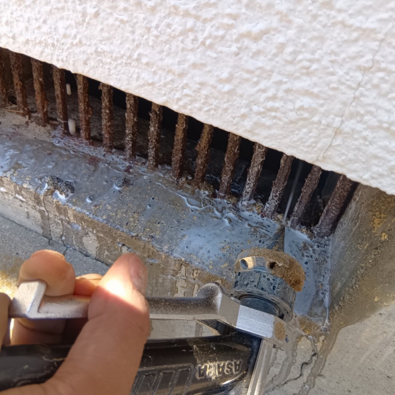 床下換気口からにシロアリ駆除剤を散布する様子