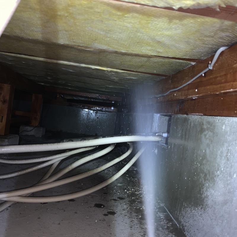 断熱材にシロアリ駆除剤を散布する様子