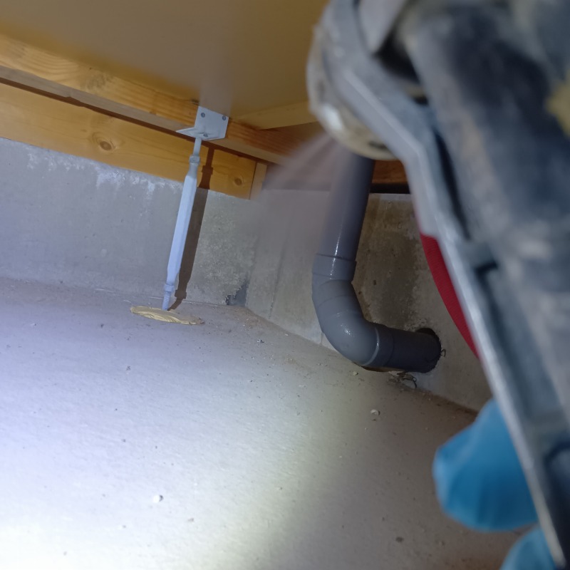 床下の地面に防蟻剤を散布する様子