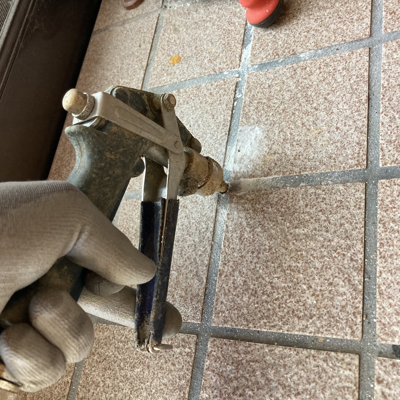 玄関床にシロアリ駆除剤を注入する様子