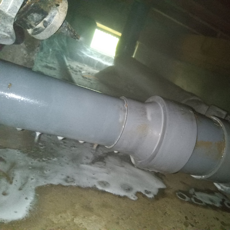 床下の地面にシロアリ駆除剤を散布する様子