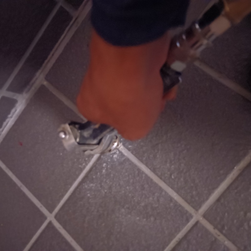 玄関床に穴を開けて薬剤を注入する様子