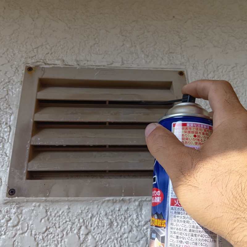 換気扇内に忌避剤を散布する様子