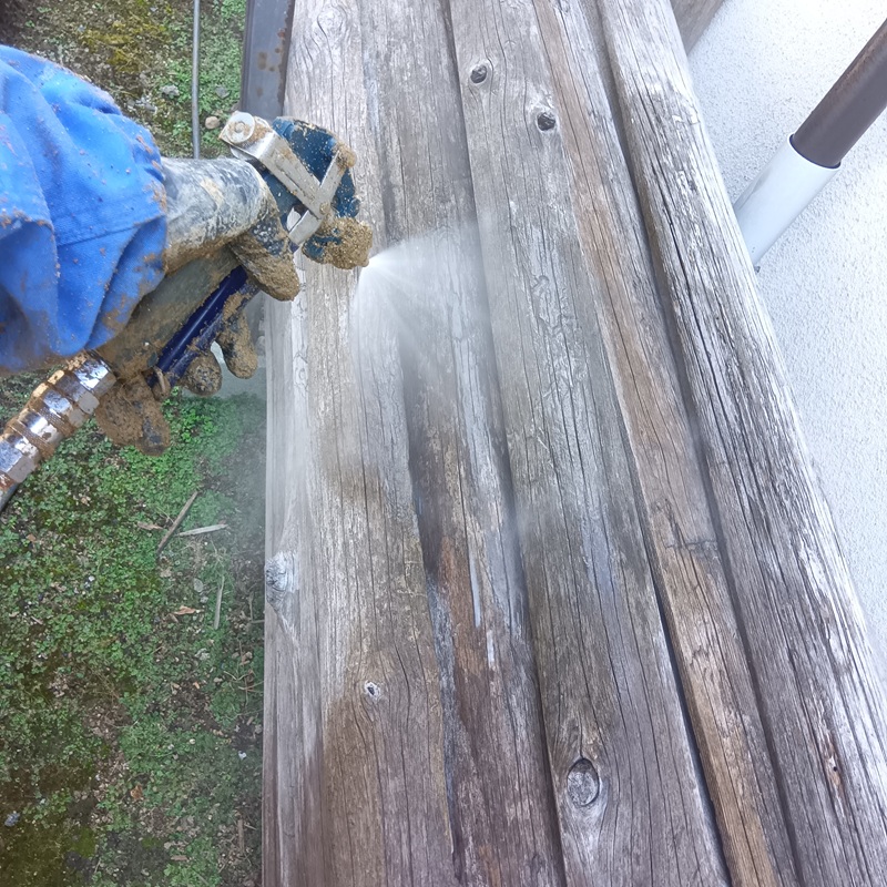 屋外に置かれた木材にシロアリ駆除剤を散布