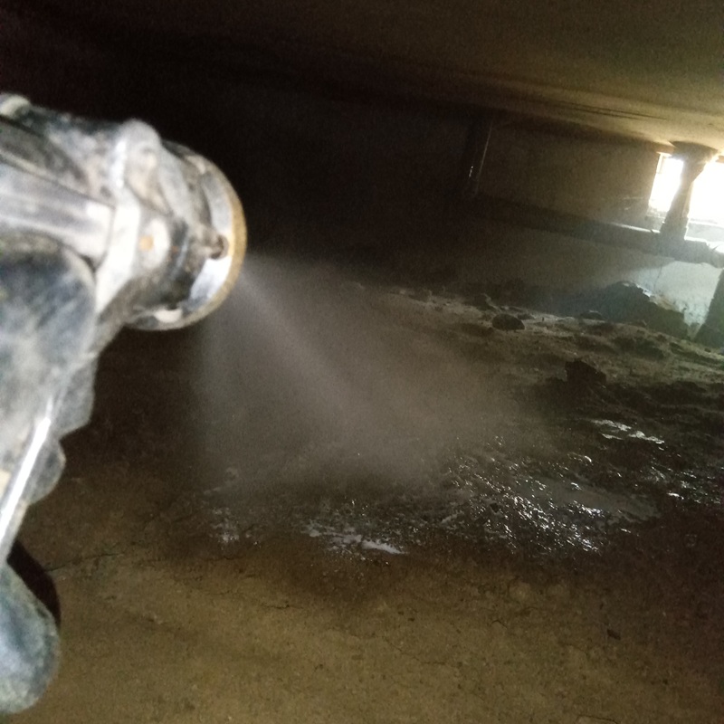 床下の地面に防蟻剤を散布している様子