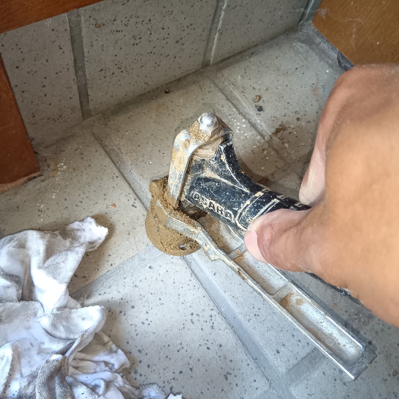 玄関床に防蟻剤を注入している様子