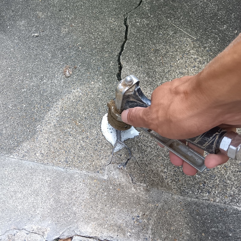 基礎の割れ目に防蟻剤を注入している様子