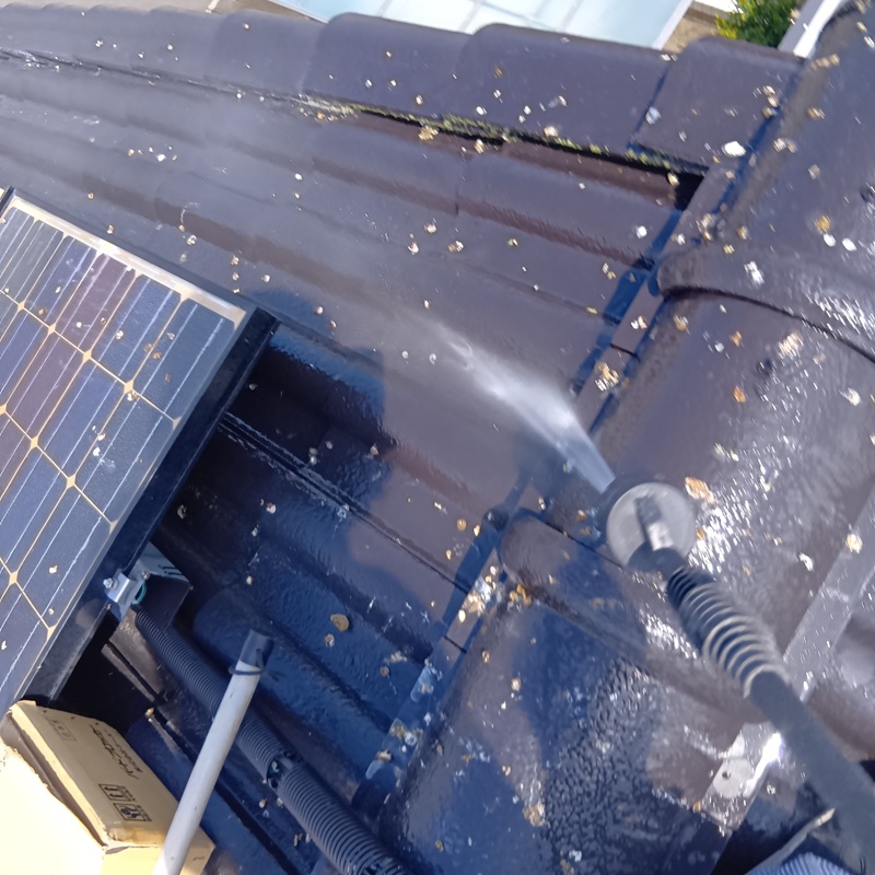 屋根のフンを高圧洗浄機で清掃する様子
