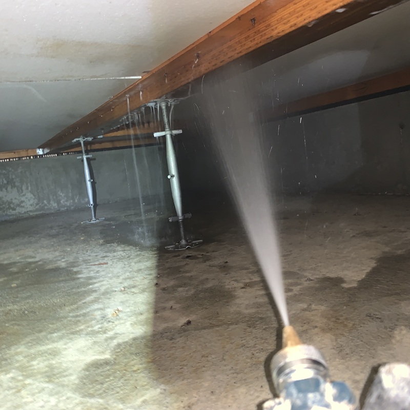 床下の木部に防蟻剤を散布する様子