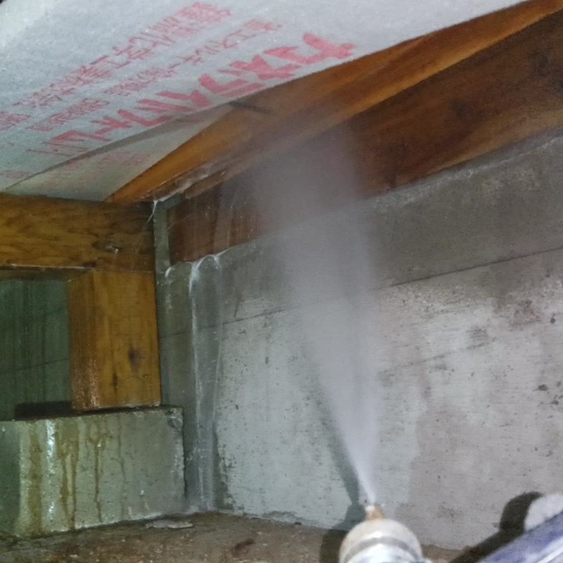 床下の木材にシロアリ駆除剤を吹き付ける様子