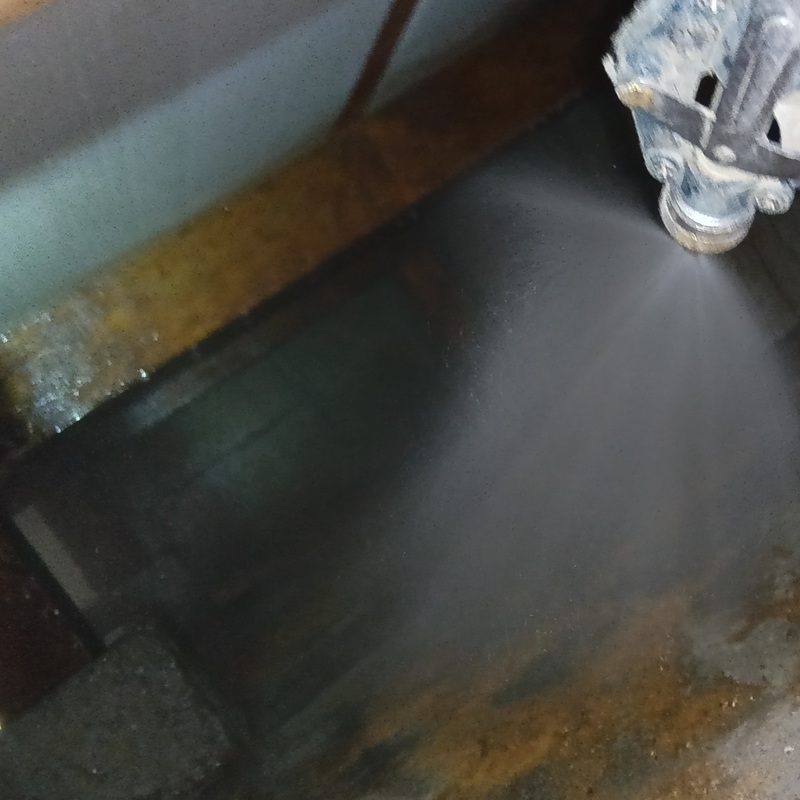 床下の地面にシロアリ駆除剤を吹き付ける様子