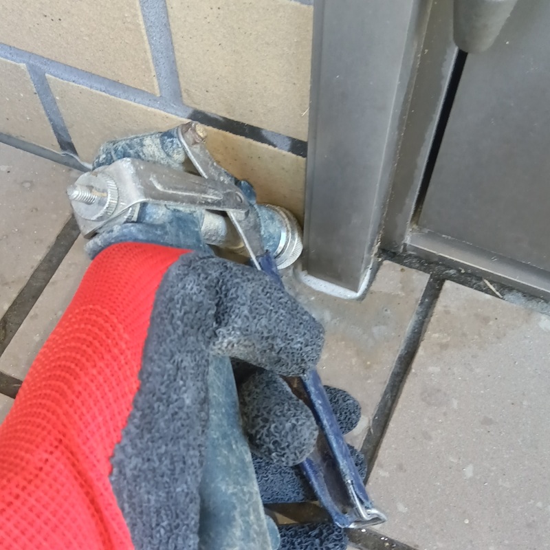 玄関の地面にシロアリ駆除剤を注入する様子