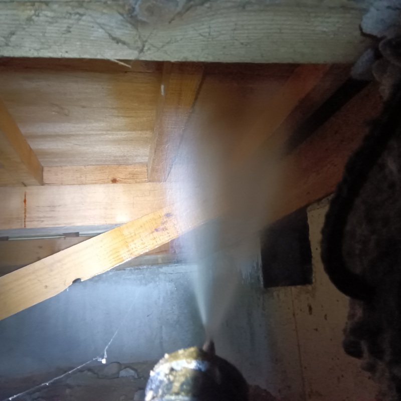 床下の木部に防蟻剤を散布する様子