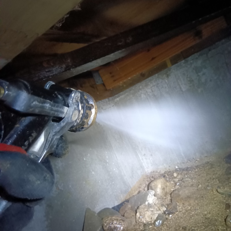 床下の地面に防蟻剤を散布する様子