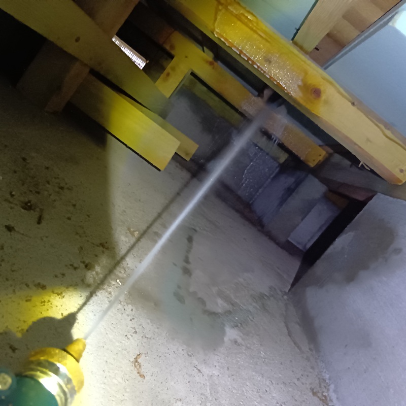 床下の木部にシロアリ駆除剤を散布する様子