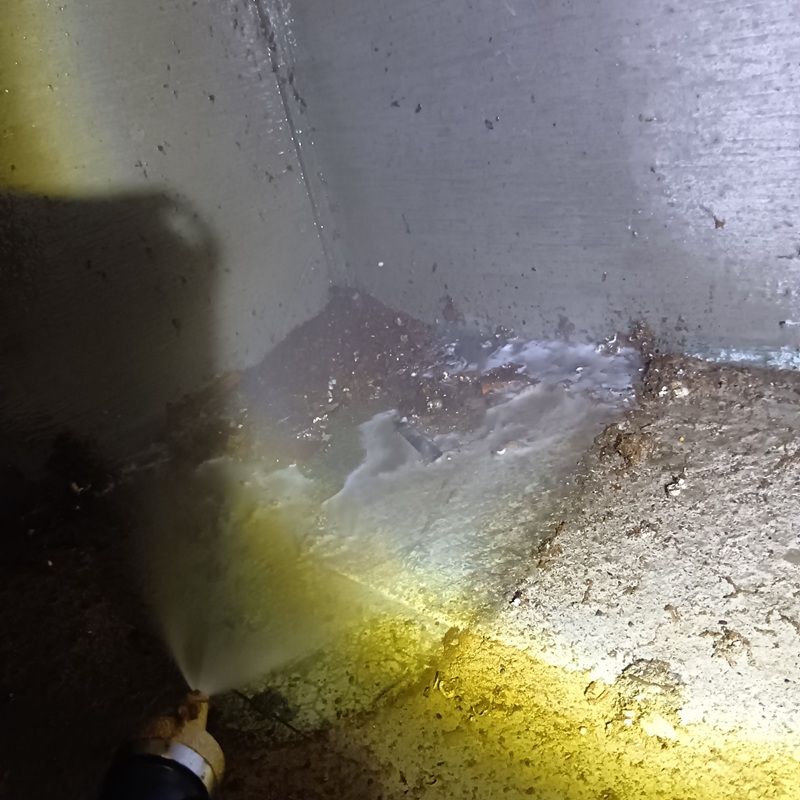 床下の地面にシロアリ駆除剤を散布する様子