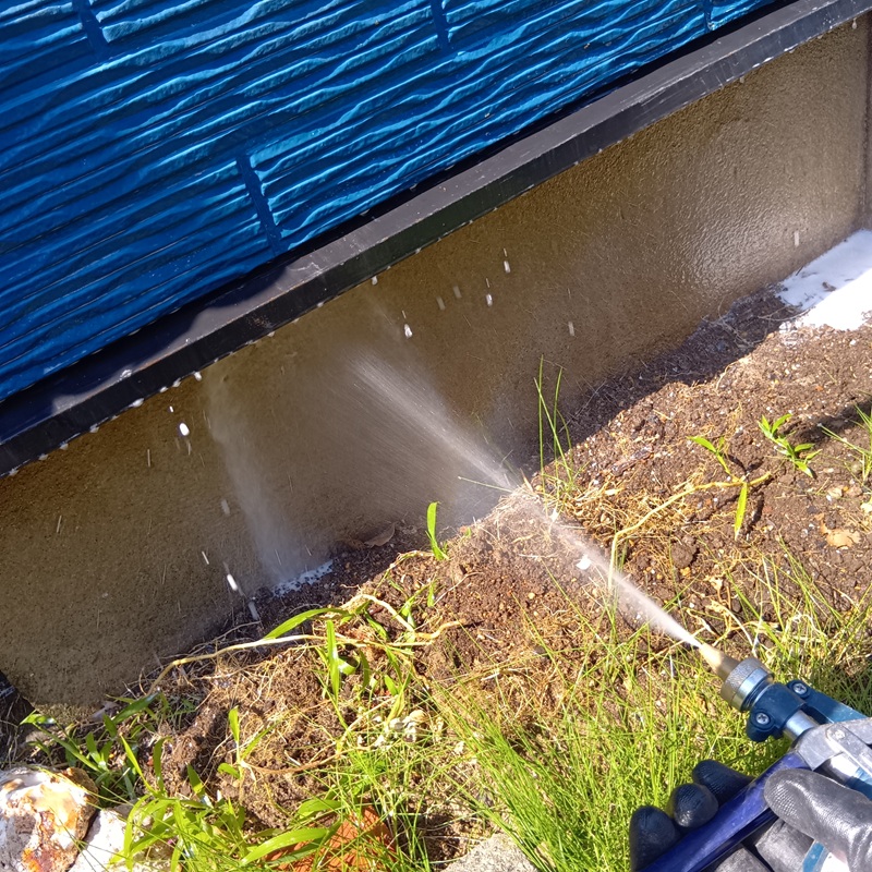 基礎周りにシロアリ駆除剤を吹き付ける様子