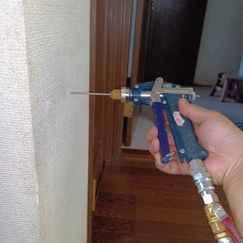 壁にシロアリ駆除剤を注入する様子