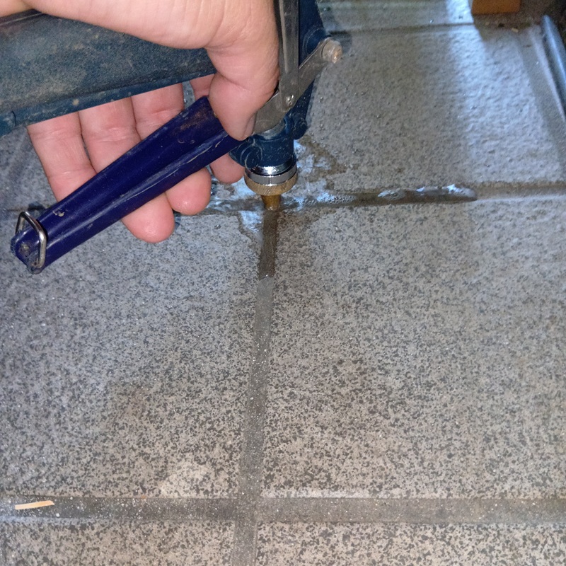 玄関床にシロアリ駆除剤を注入する様子